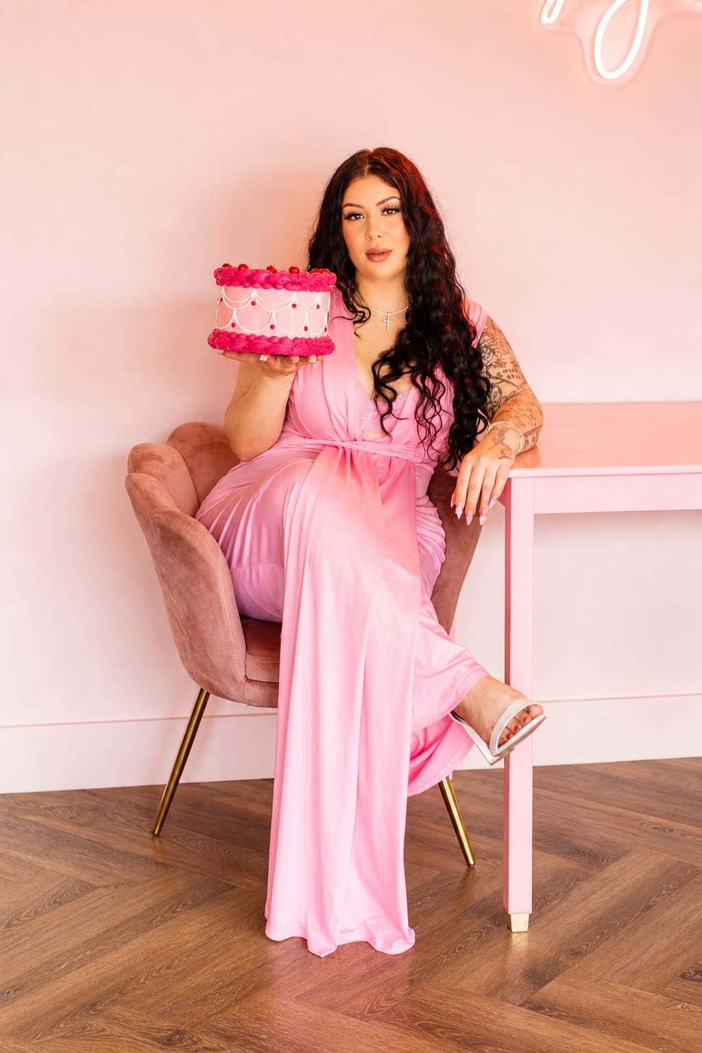 Aaliyah, owner of Hella Cakes, holding a pink heart cake